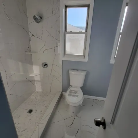 a bathroom with a toilet and a shower