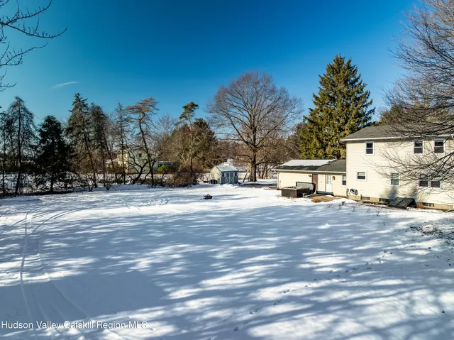 a view of a house with a large window and wooden fence
