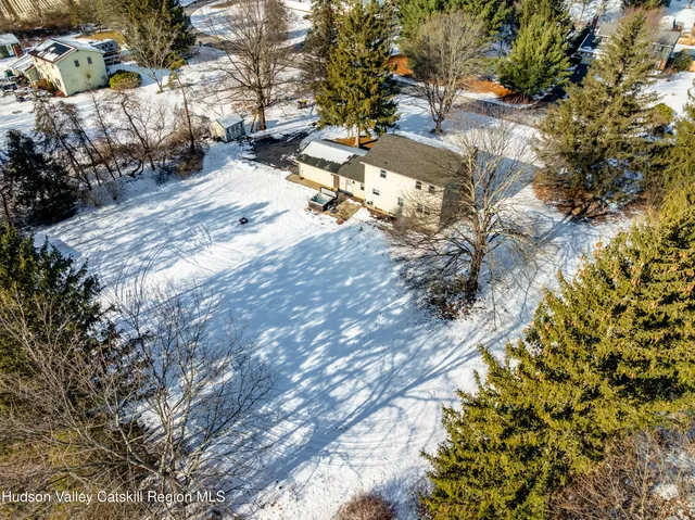 an empty room with windows fireplace and wooden floor
