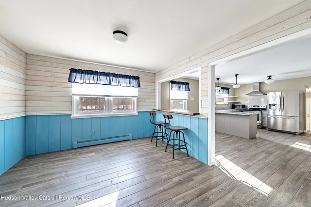 a kitchen with a sink dishwasher stove and white cabinets with wooden floor