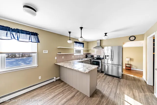 a view of empty room with wooden floor and window