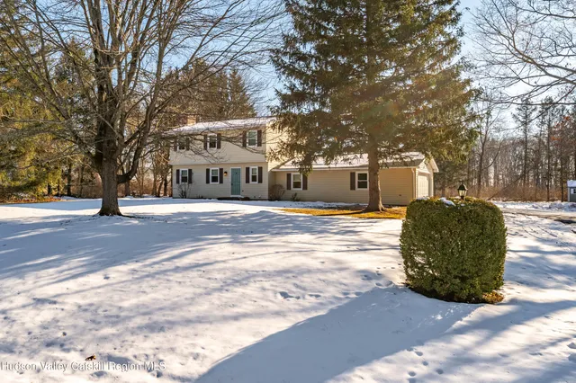 a front view of a building with large trees