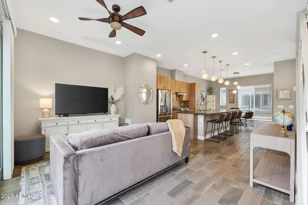 a kitchen with stainless steel appliances granite countertop a kitchen island a stove a refrigerator a oven a sink a dining table and chairs with wooden floor