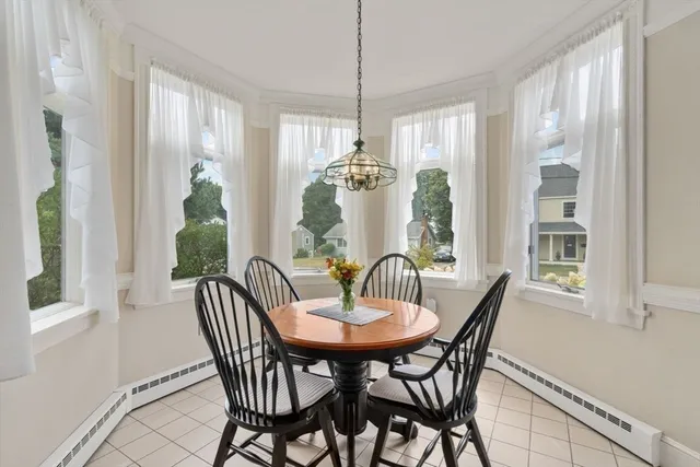 a dining room with furniture large windows and a chandelier