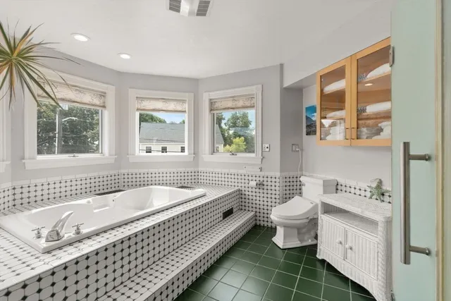 a spacious bathroom with a tub a toilet a sink and a window