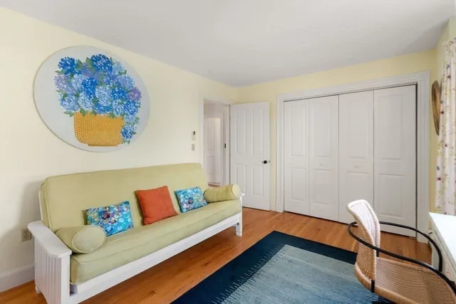 a living room with a couch and a dining table with wooden floor