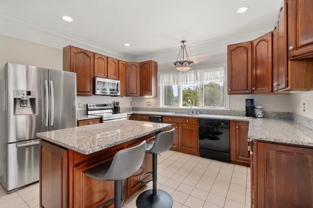 a kitchen with stainless steel appliances granite countertop a stove refrigerator sink and microwave