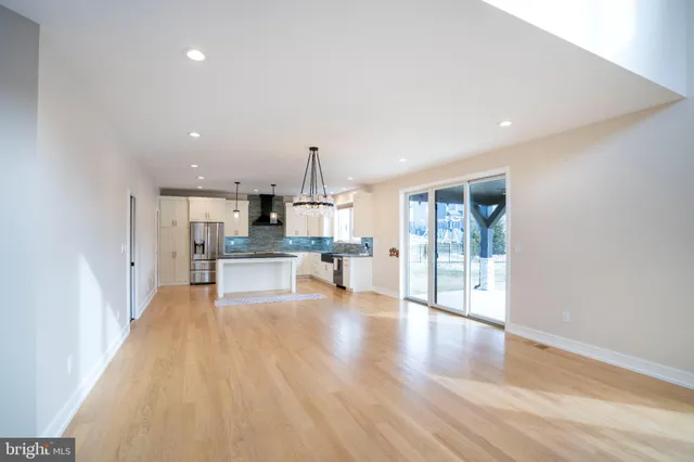 a kitchen with stainless steel appliances granite countertop a sink a stove and a wooden floor