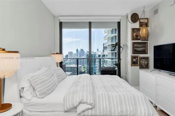 a bedroom with a bed and a large window