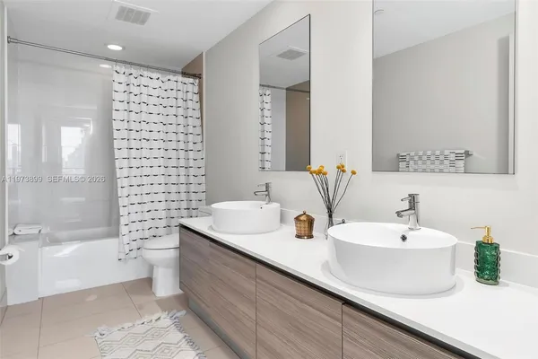 a bathroom with a double vanity sink toilet and shower