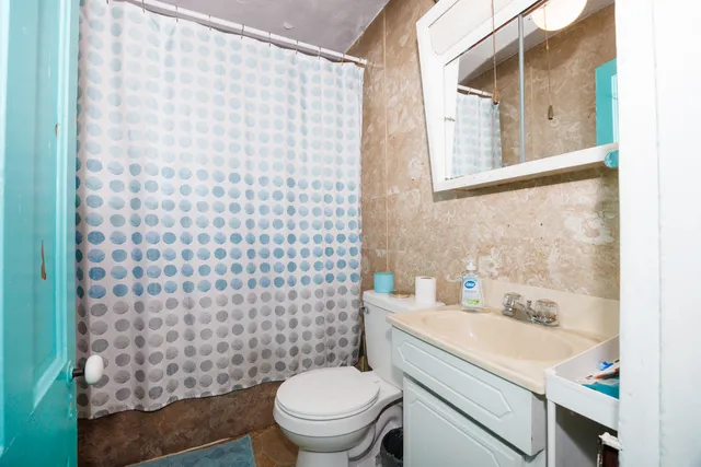 a bathroom with a sink a toilet and shower curtain