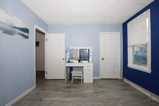 a view of a workspace with furniture and a window