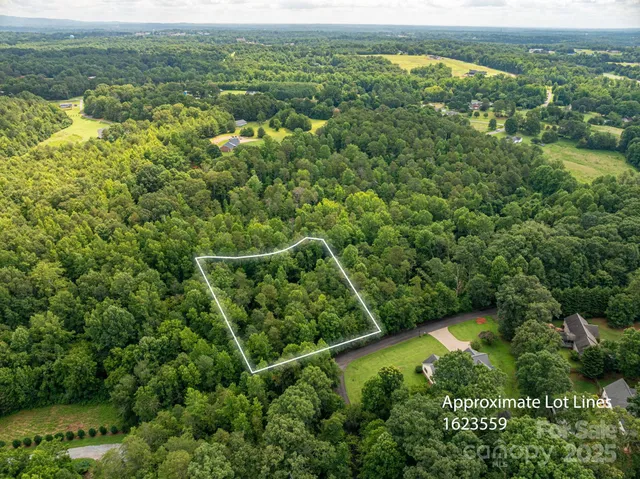 an aerial view of residential houses with outdoor space and trees