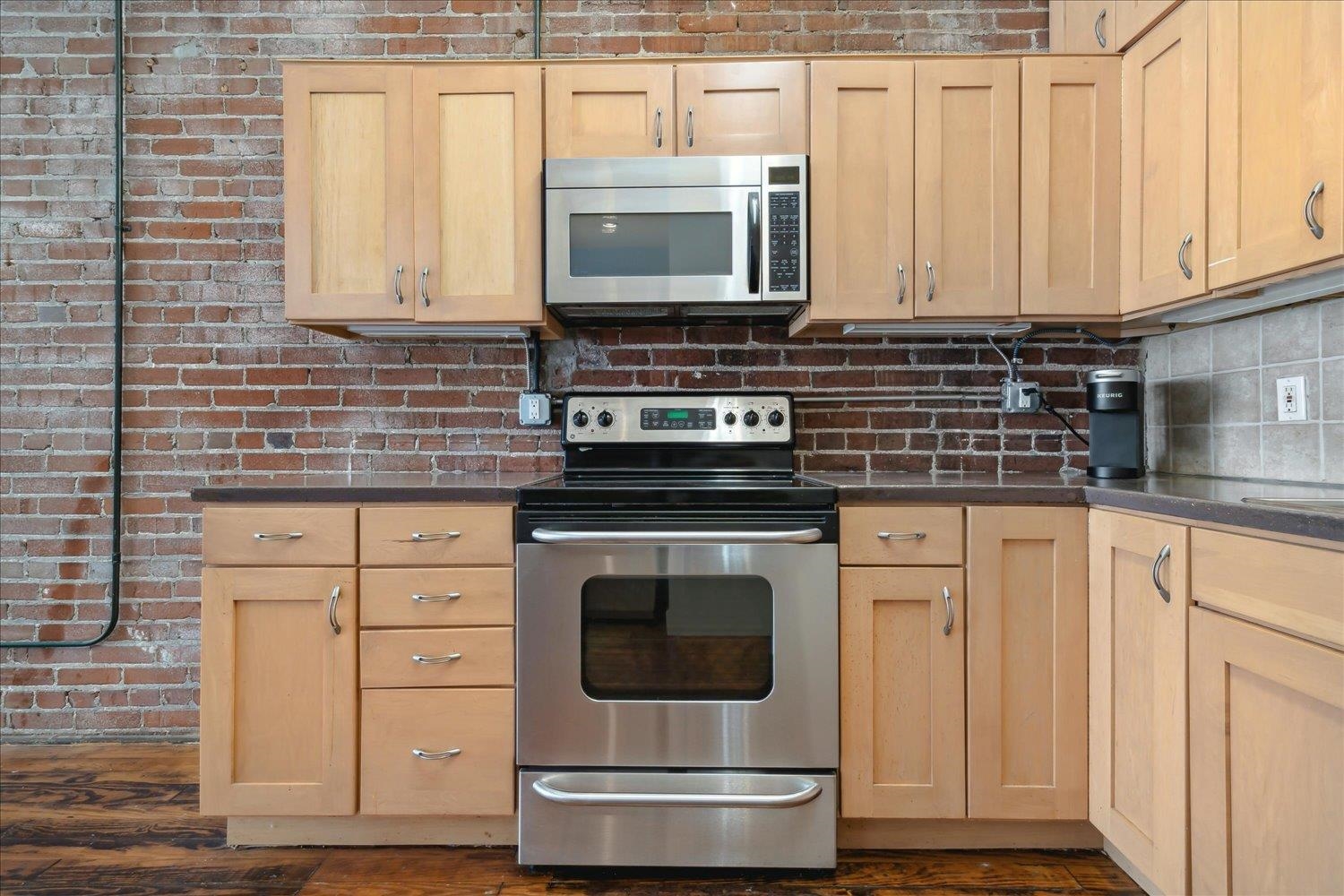 413 South Main Street, Unit 206 Memphis, TN 38103 - Photo 10 of 23 a kitchen with stainless steel appliances granite countertop a stove a microwave and a sink