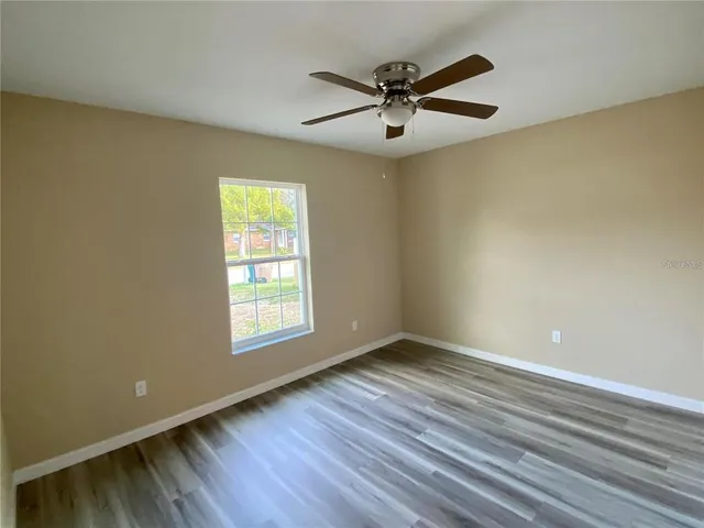 a view of a big room with wooden floor and windows