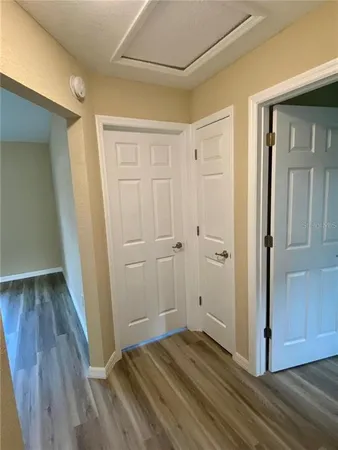 a view of a hallway with wooden floor and closet area