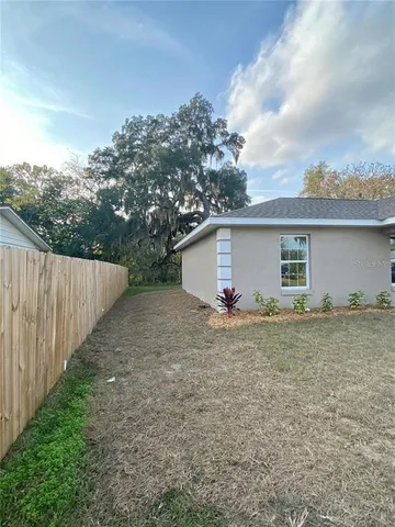 a view of backyard of house and trees