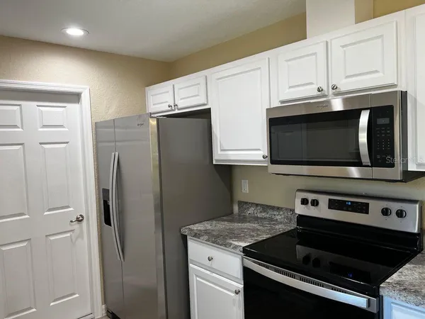 a kitchen with stainless steel appliances a stove a microwave and cabinets