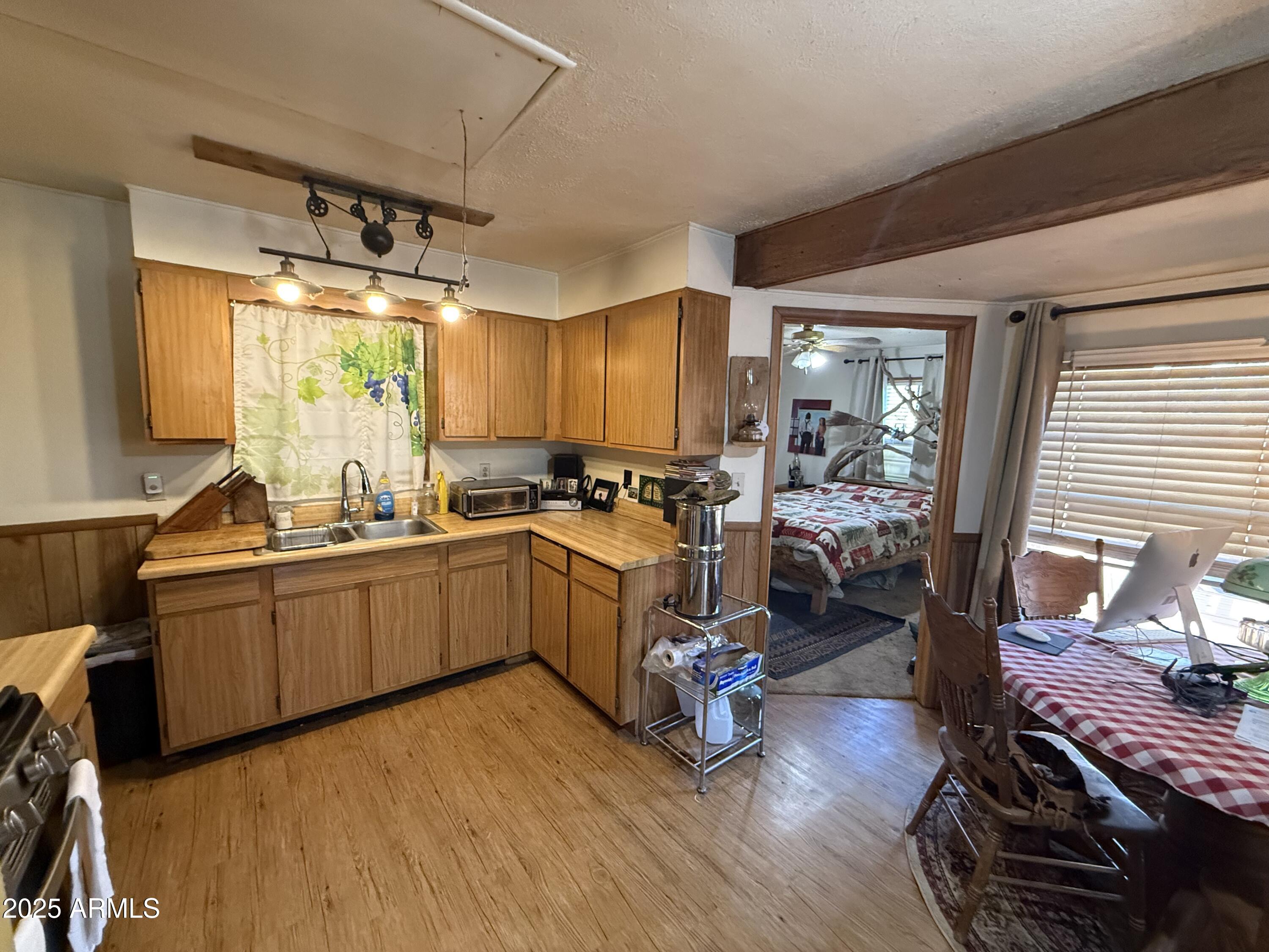 23576 Sunny South Road Crown King, AZ 86343 - Photo 6 of 29 a kitchen with sink cabinets and wooden floor