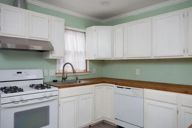 a kitchen with stainless steel appliances granite countertop white cabinets a sink and dishwasher