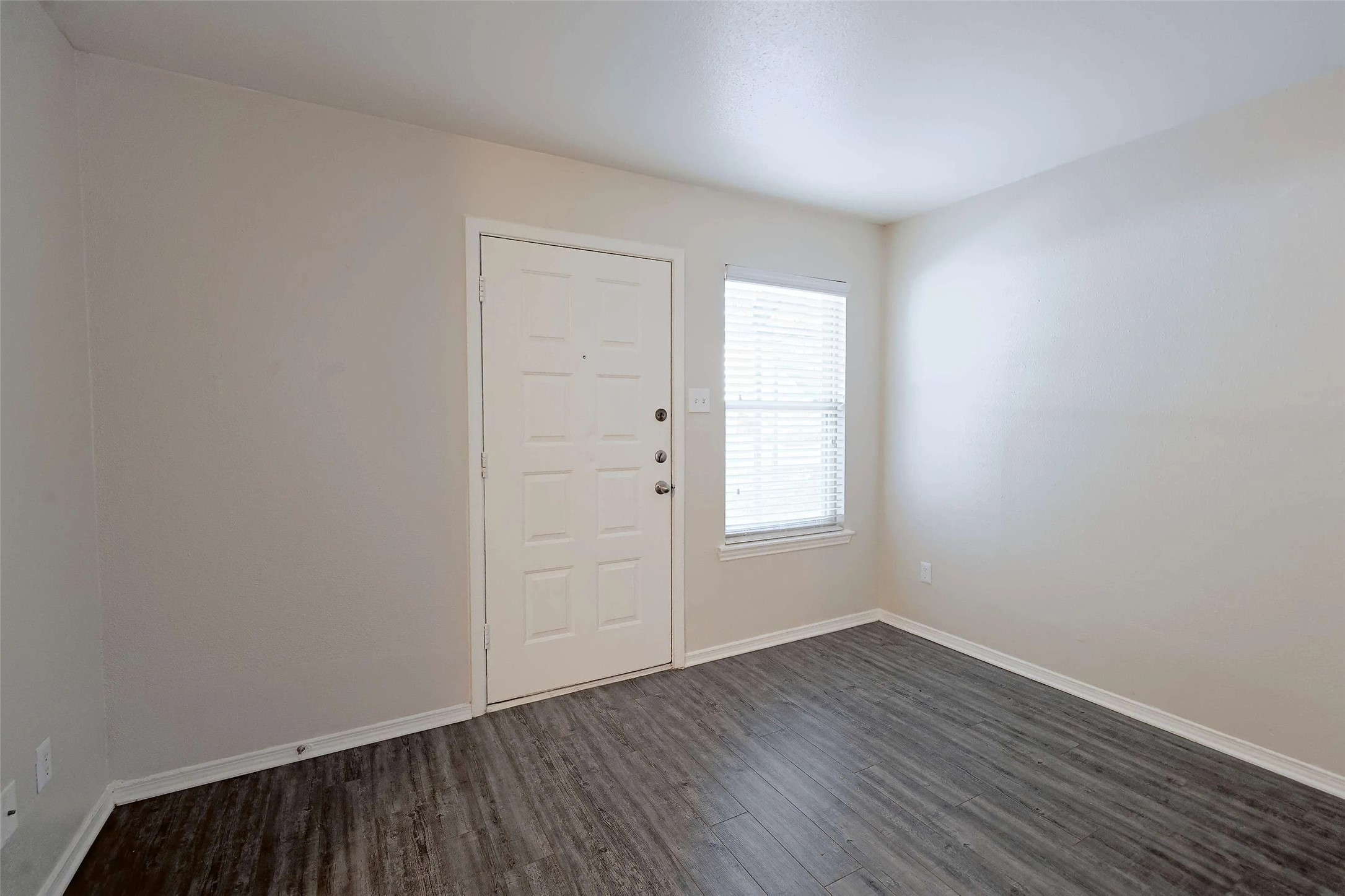2809 West William Cannon Drive, Unit I101 Austin, TX 78745 - Photo 10 of 29 Entrance foyer featuring baseboards and dark wood-style flooring