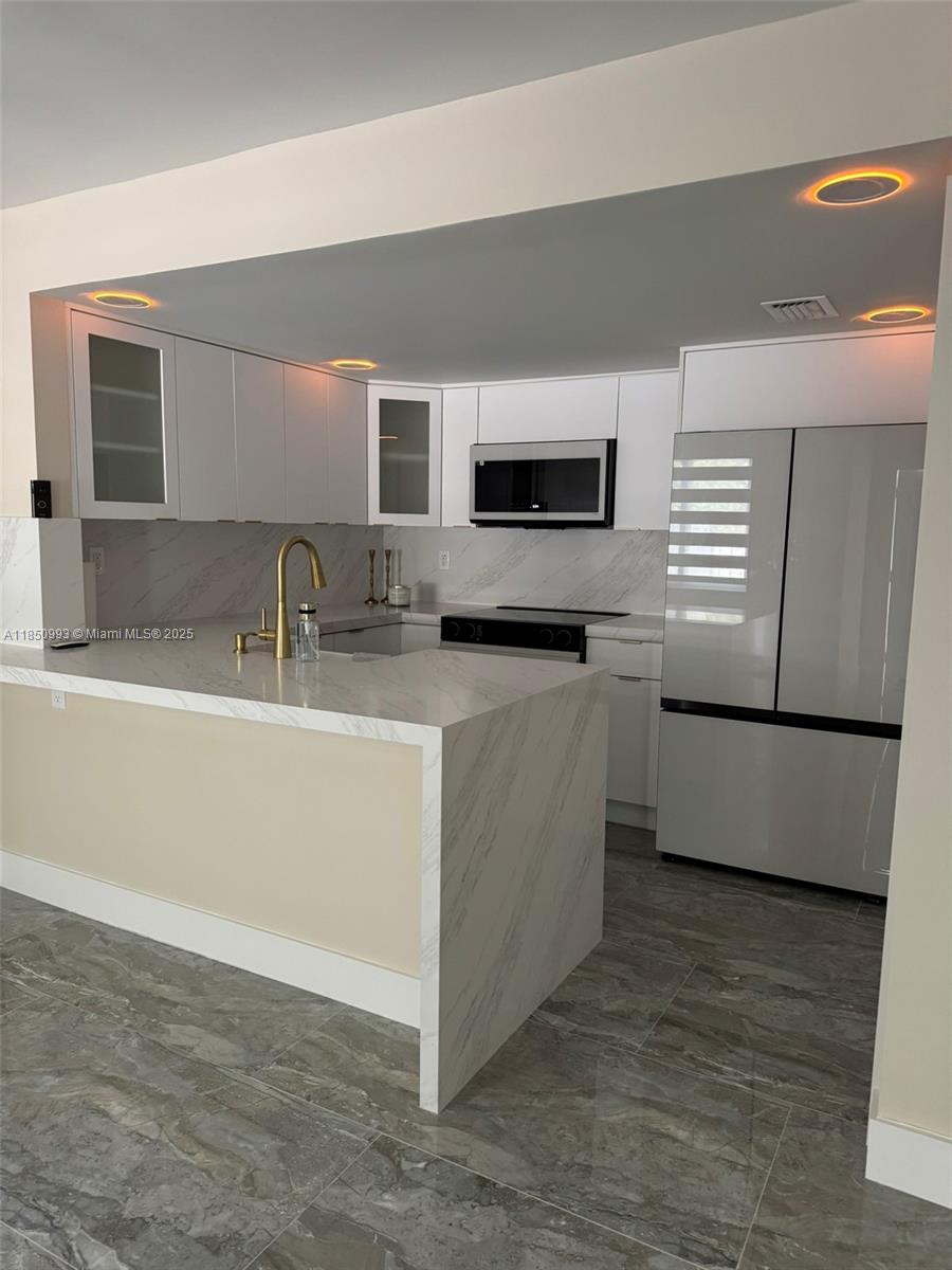 4520 Southwest 68th Ct Circle, Unit 305 Miami, FL 33155 - Photo 15 of 46 a kitchen with stainless steel appliances granite countertop a sink and a microwave