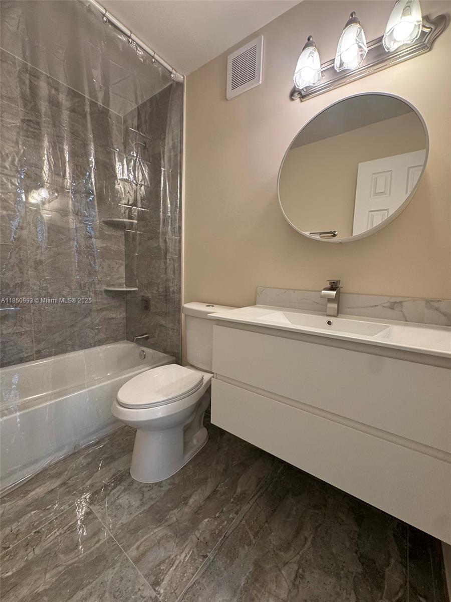 4520 Southwest 68th Ct Circle, Unit 305 Miami, FL 33155 - Photo 30 of 46 a bathroom with a toilet a sink and a mirror