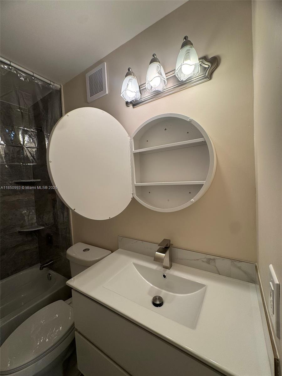 4520 Southwest 68th Ct Circle, Unit 305 Miami, FL 33155 - Photo 34 of 46 a bathroom with a sink a mirror a lamp and a mirror