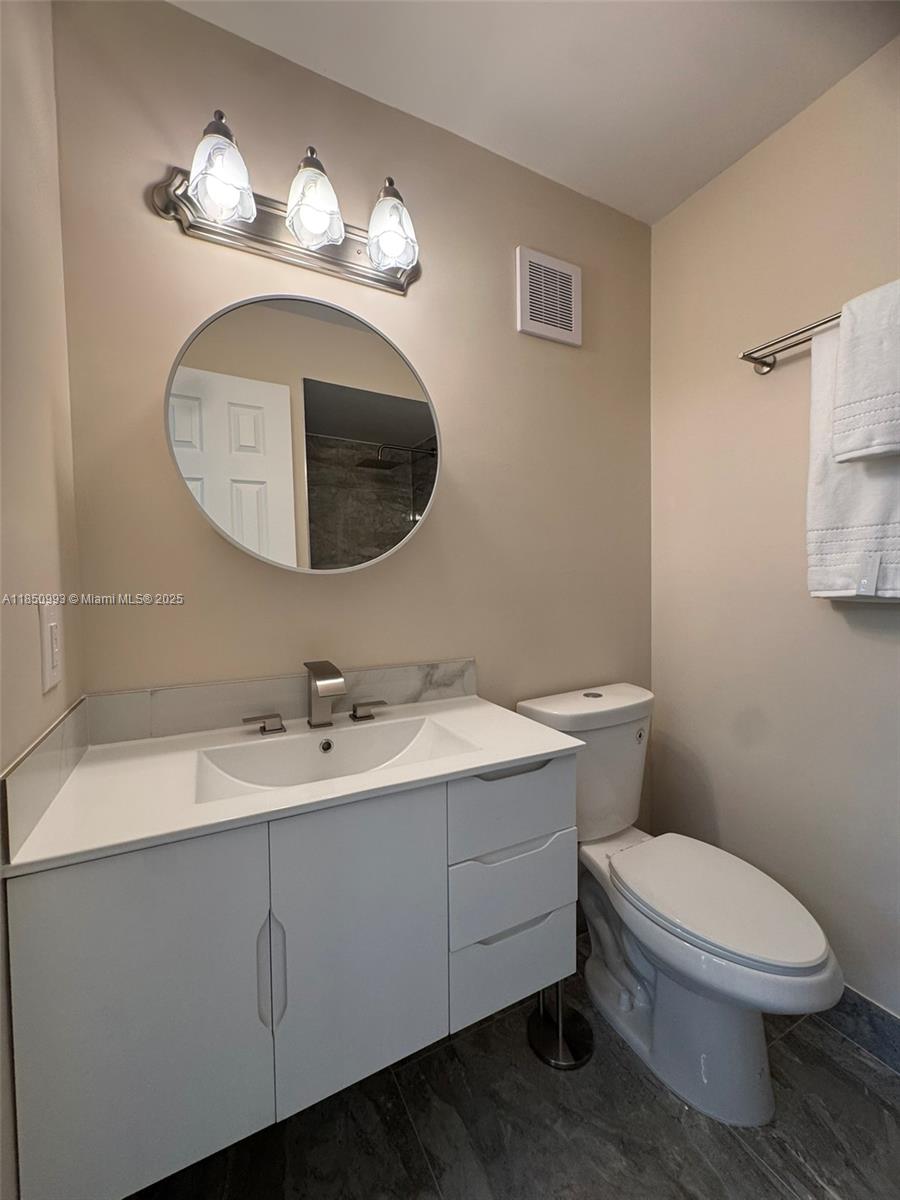 4520 Southwest 68th Ct Circle, Unit 305 Miami, FL 33155 - Photo 37 of 46 a bathroom with a toilet a sink and mirror
