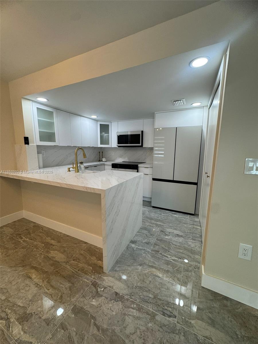 4520 Southwest 68th Ct Circle, Unit 305 Miami, FL 33155 - Photo 9 of 46 a large white kitchen with a sink a refrigerator and a stove top oven