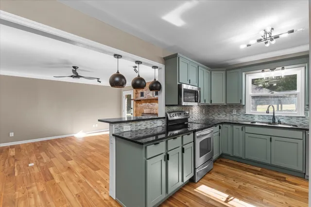 a kitchen with stainless steel appliances granite countertop a sink stove and cabinets