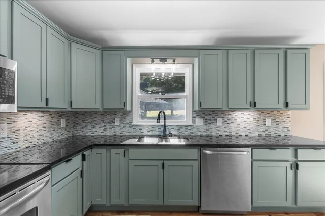 a kitchen with granite countertop a sink and cabinets