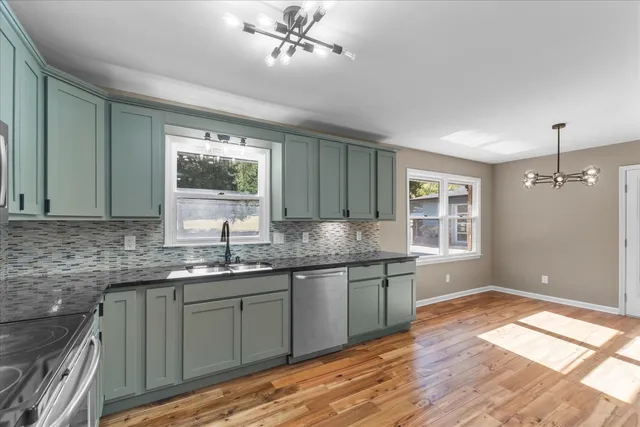 a kitchen with stainless steel appliances granite countertop a sink and cabinets