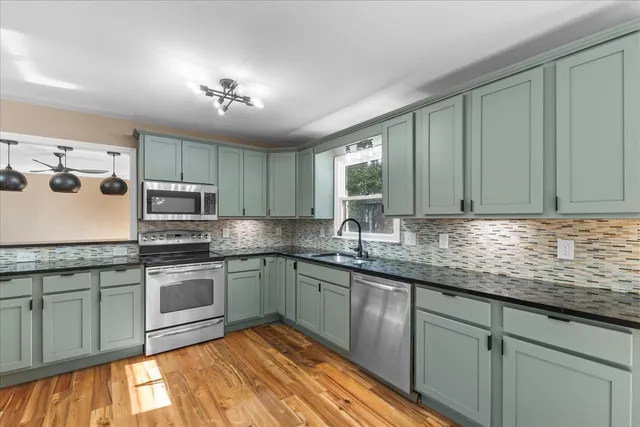 a kitchen with stainless steel appliances granite countertop a refrigerator and a sink
