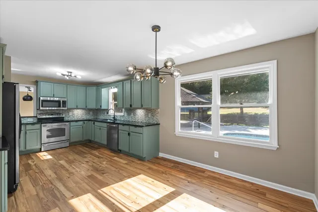 a kitchen with stainless steel appliances granite countertop a refrigerator a stove top oven a sink and dishwasher