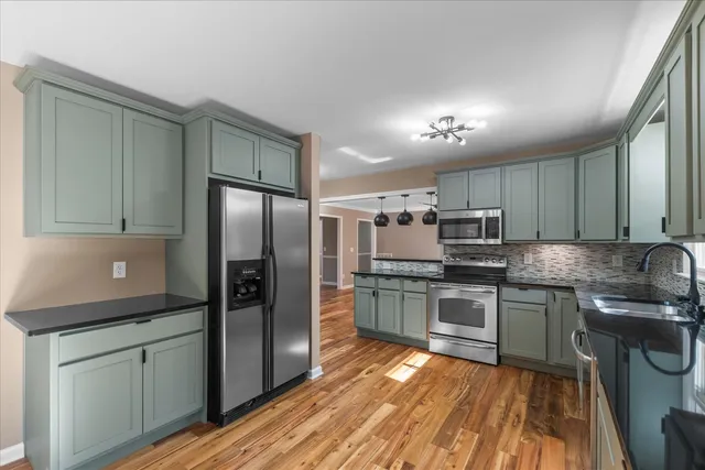 a kitchen with stainless steel appliances granite countertop a refrigerator and a sink