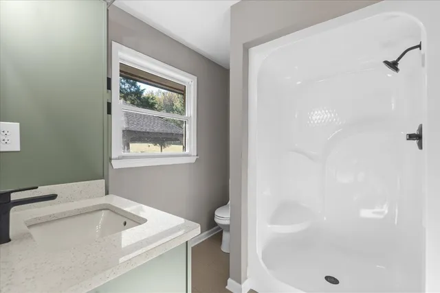 a bathroom with a toilet a sink and mirror