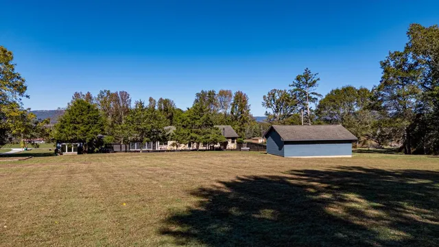 an aerial view of a house with a yard and lake view