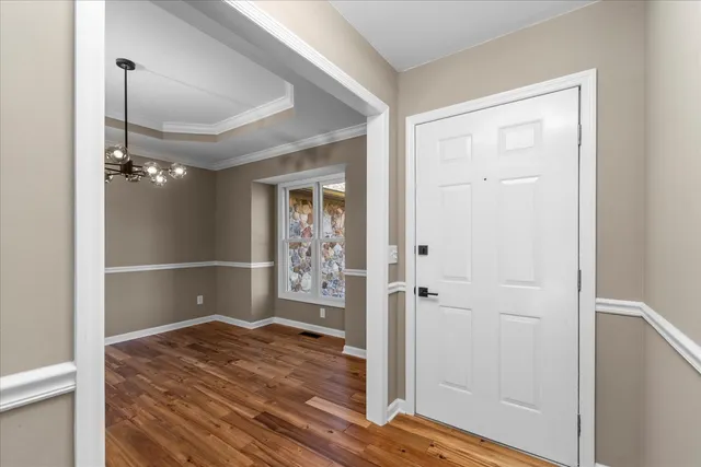a view of a hallway with wooden floor and closet