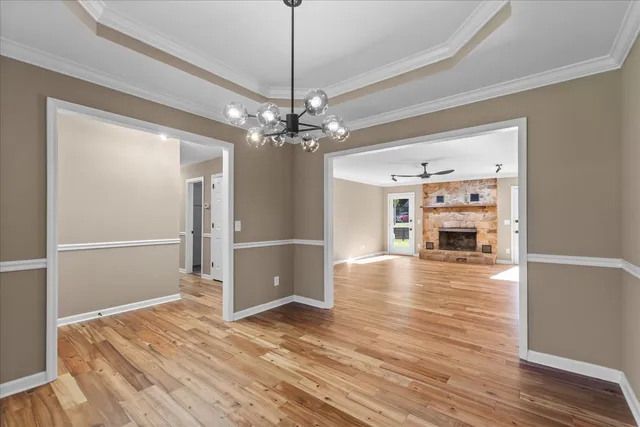 a view of a livingroom with wooden floor and a ceiling fan