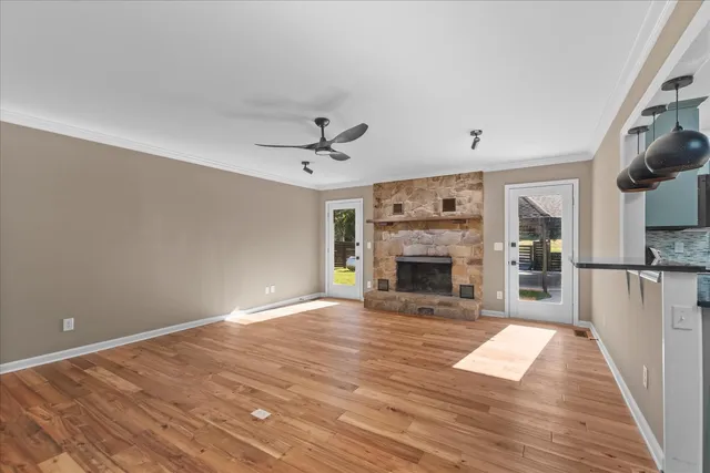 a view of a livingroom with wooden floor a fireplace and entryway