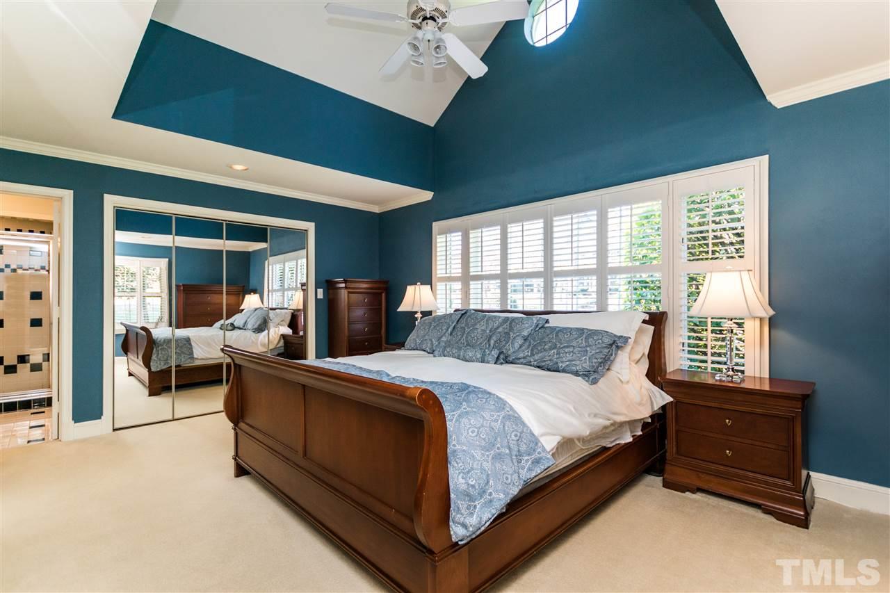 1422 Canterbury Road Raleigh, NC 27608 - Photo 16 of 25 a large bedroom with a large bed and a chandelier