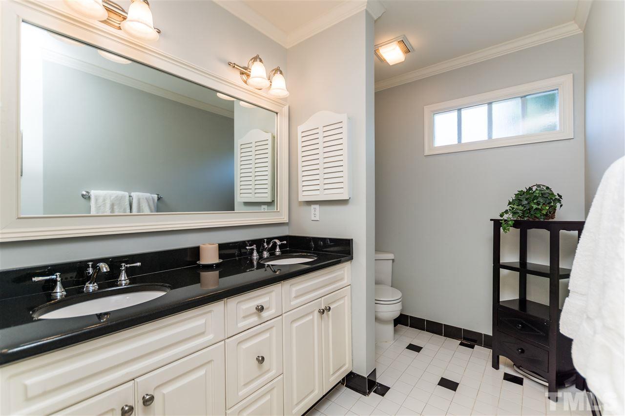 1422 Canterbury Road Raleigh, NC 27608 - Photo 18 of 25 a bathroom with a granite countertop sink a toilet and a mirror