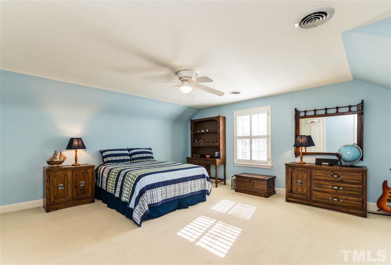 1422 Canterbury Road Raleigh, NC 27608 - Photo 21 of 25 a spacious bedroom with a bed dresser and a window