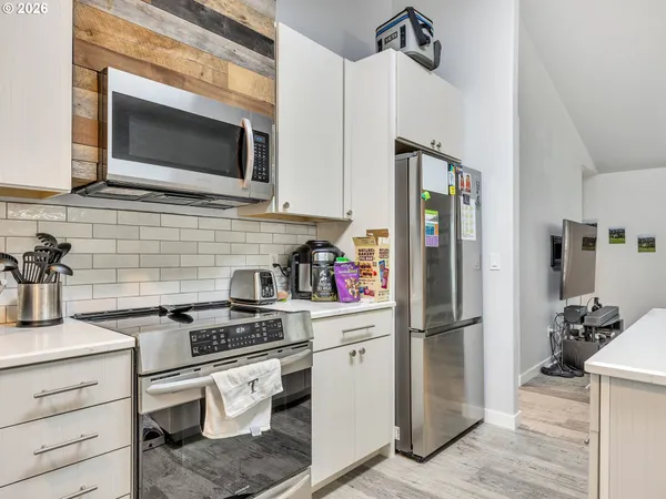 a kitchen with stainless steel appliances a refrigerator stove and microwave