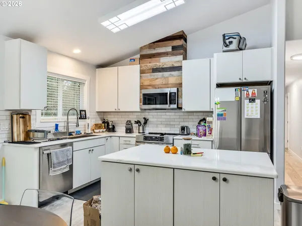 a kitchen with stainless steel appliances a sink cabinets and a refrigerator