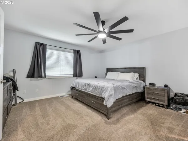 a spacious bedroom with a bed and a chandelier