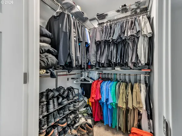 a view of walk in closet with clothes and shoes
