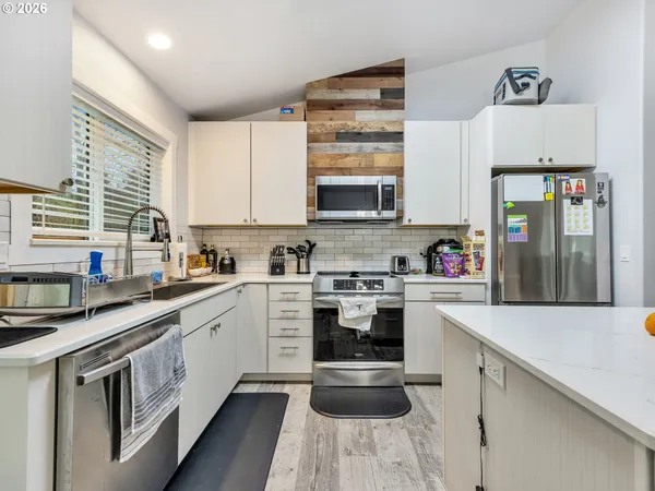 a kitchen with stainless steel appliances kitchen island granite countertop a stove and a sink