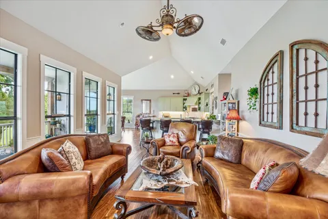 a living room with furniture kitchen view and a large window
